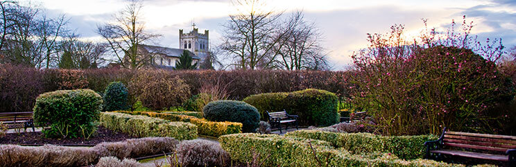 Garden park with benches and church in the distance in Waltham, Massachusetts